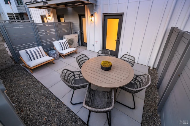 view of patio with fence, outdoor dining space, and ac unit