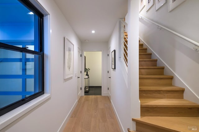 corridor with stairway, recessed lighting, light wood finished floors, and baseboards