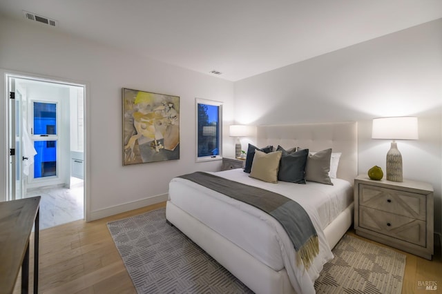 bedroom with visible vents, baseboards, and light wood-style floors