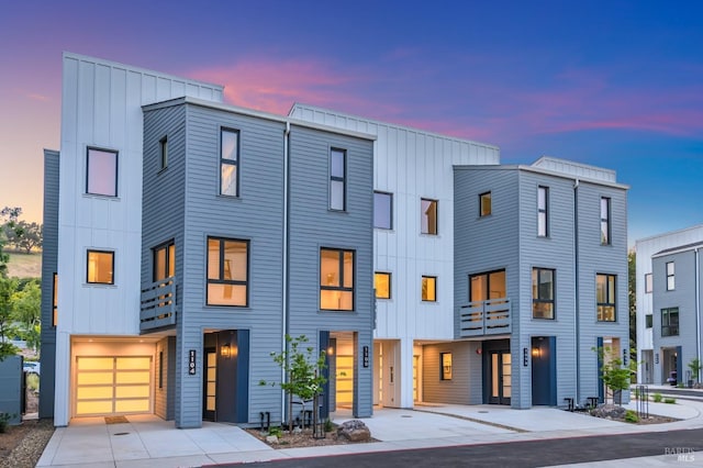 multi unit property featuring driveway, board and batten siding, and a balcony