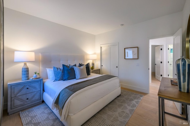 bedroom with light wood-style floors and baseboards