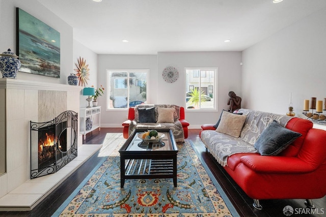 living room featuring recessed lighting, baseboards, a tiled fireplace, and wood finished floors