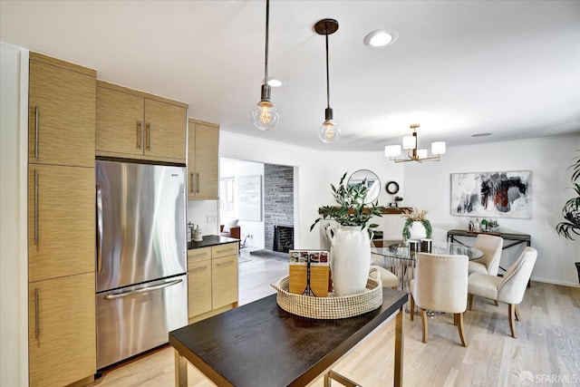 1751 Leimert Blvd, Oakland, CA 94602 - kitchen with freestanding refrigerator, a chandelier, light wood finished floors, dark countertops, and pendant lighting