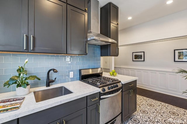 1034 Jackson St, San Francisco, CA 94133 - kitchen with gas range, wall chimney range hood, light stone counters, tasteful backsplash, and wainscoting