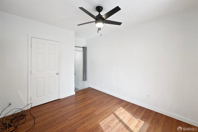 unfurnished bedroom featuring a ceiling fan, wood finished floors, and baseboards