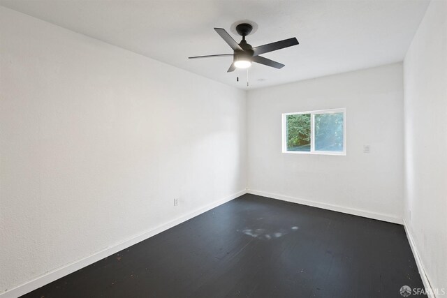 unfurnished room featuring dark wood-style floors, baseboards, and ceiling fan