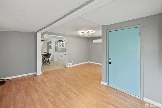 unfurnished room featuring baseboards, visible vents, and light wood finished floors