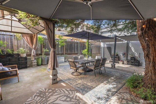view of patio featuring a gazebo, a fenced backyard, and outdoor dining area