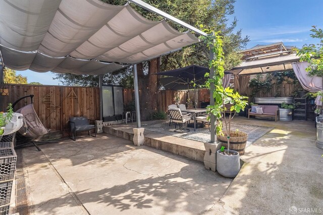 view of patio with a gazebo, outdoor dining space, and a fenced backyard