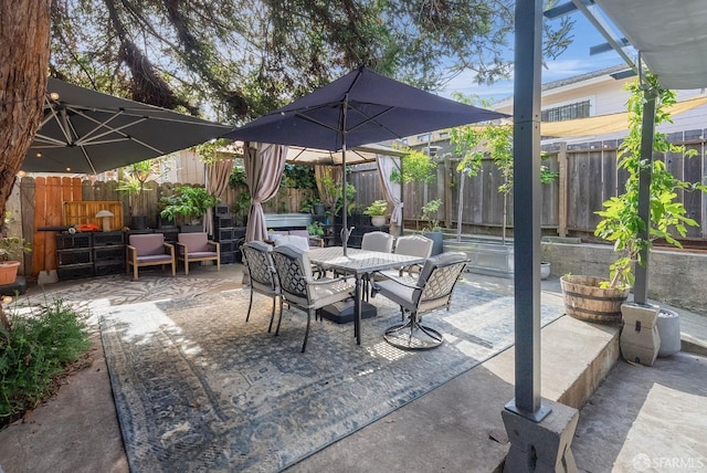 view of patio with a fenced backyard and outdoor dining area