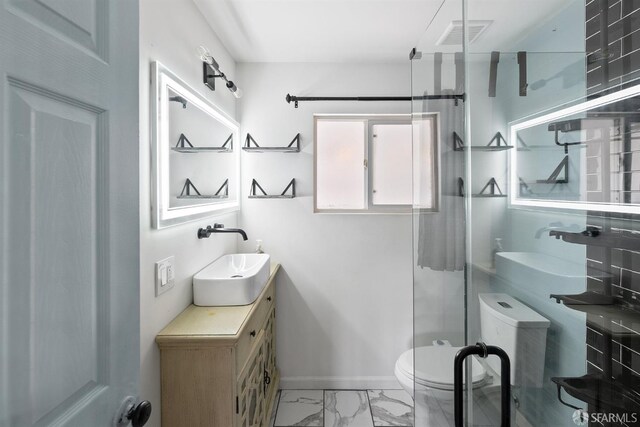 bathroom with a stall shower, baseboards, toilet, vanity, and marble finish floor