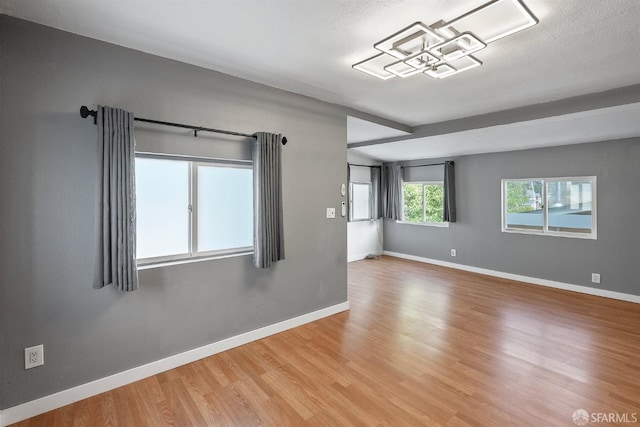 empty room featuring wood finished floors and baseboards