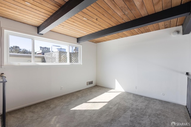 carpeted empty room featuring wooden ceiling, baseboards, visible vents, and beam ceiling