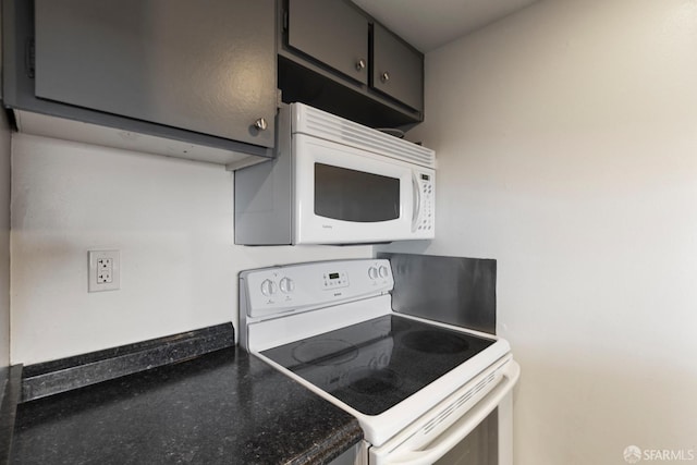 kitchen with white appliances and dark countertops