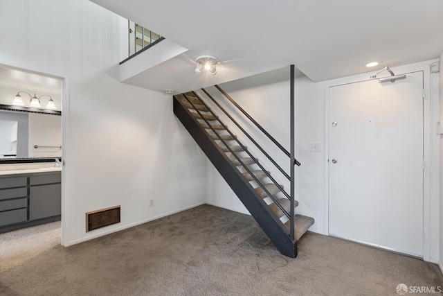 finished basement featuring carpet floors and stairs