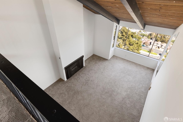 interior space featuring lofted ceiling with beams, wood ceiling, and carpet flooring