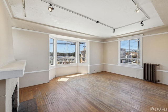 2440-2442 Balboa St, San Francisco, CA 94121 - unfurnished living room featuring radiator heating unit, rail lighting, hardwood / wood-style floors, and a fireplace with flush hearth