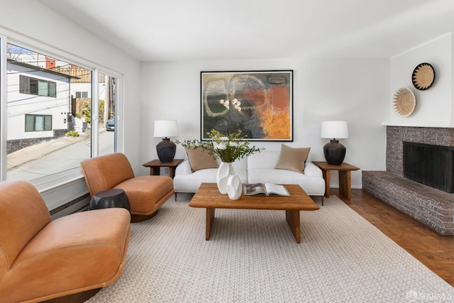 sitting room featuring a baseboard heating unit, parquet floors, and a tiled fireplace