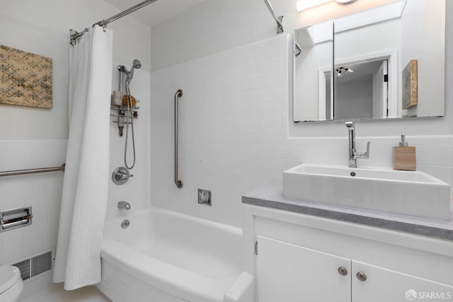 full bathroom with toilet, shower / bath combination with curtain, vanity, and tile walls