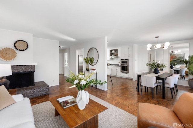 living room featuring dark parquet flooring and a notable chandelier