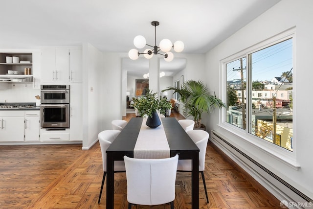 dining space featuring a baseboard heating unit, dark parquet flooring, and an inviting chandelier