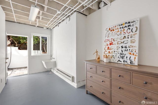 interior space featuring baseboard heating, concrete floors, and sink