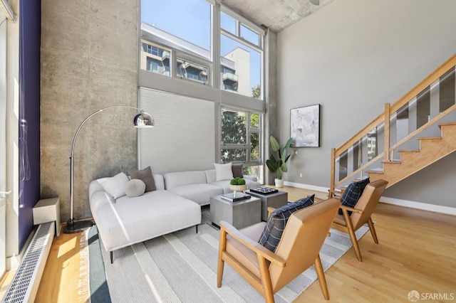 311 Oak St Unit 301, Oakland, CA 94607 - living area with wood finished floors, a towering ceiling, baseboards, and stairs