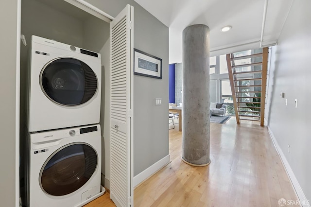 311 Oak St Unit 301, Oakland, CA 94607 - laundry room with estacked washer and dryer, wood finished floors, ornate columns, and baseboards