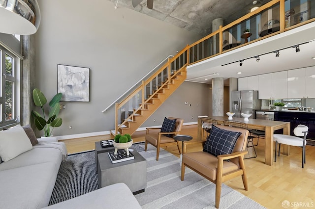 311 Oak St Unit 301, Oakland, CA 94607 - living room with baseboards, light wood-style floors, stairs, and rail lighting