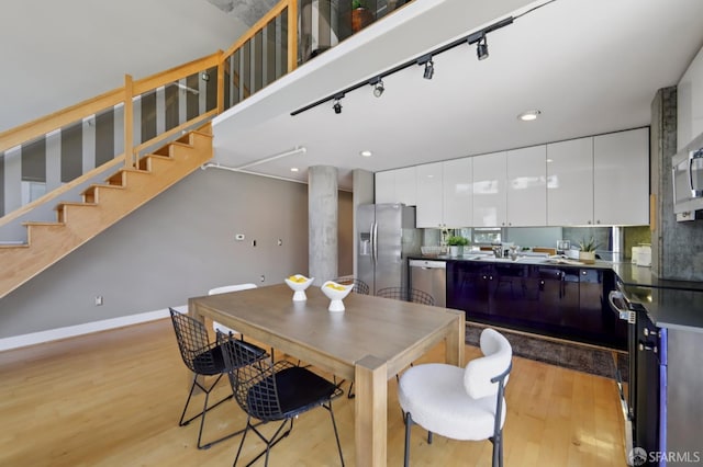 311 Oak St Unit 301, Oakland, CA 94607 - dining area with light wood finished floors, stairs, recessed lighting, and rail lighting