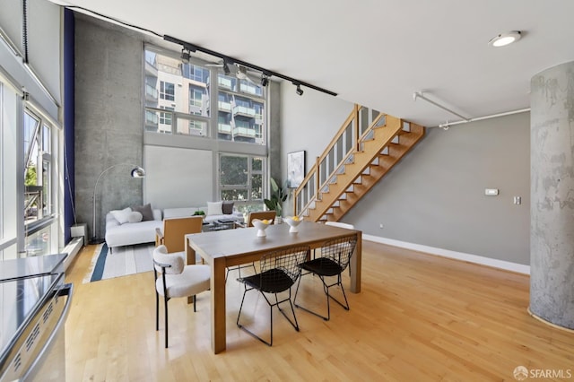 311 Oak St Unit 301, Oakland, CA 94607 - dining room with wood finished floors, stairway, baseboards, and a high ceiling