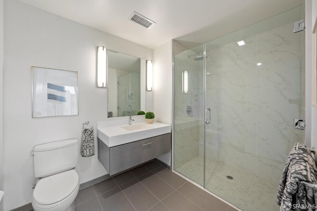 bathroom featuring tile patterned floors, a shower with door, vanity, and toilet