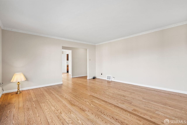 spare room with ornamental molding and light wood-type flooring