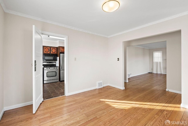 empty room featuring hardwood / wood-style floors and ornamental molding