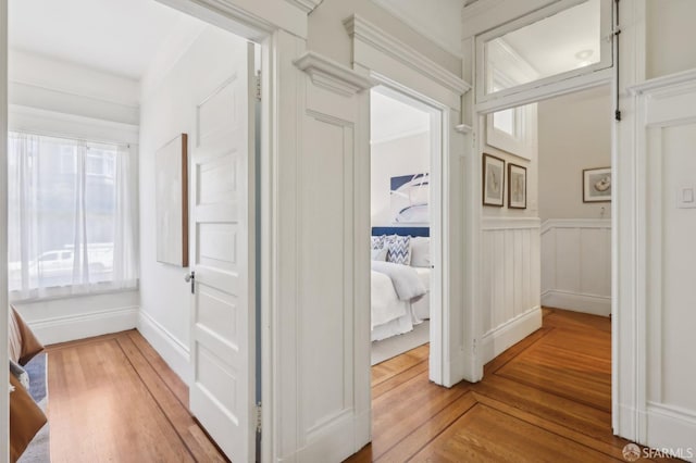 hallway with wood finished floors and wainscoting