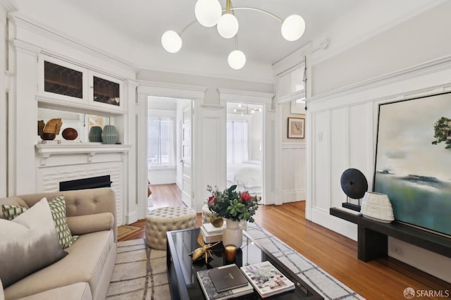 living area with a high end fireplace, a decorative wall, and light wood finished floors