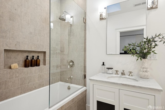 full bath with visible vents, tiled shower / bath combo, and vanity