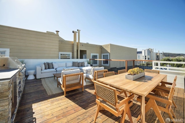 wooden deck featuring a grill, an outdoor hangout area, and outdoor dining space