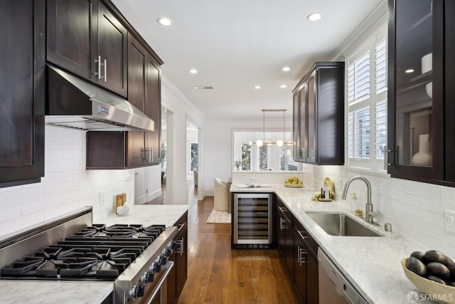 kitchen featuring wine cooler, under cabinet range hood, a sink, light stone countertops, and gas stove