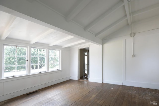 unfurnished room featuring plenty of natural light, vaulted ceiling with beams, and hardwood / wood-style floors