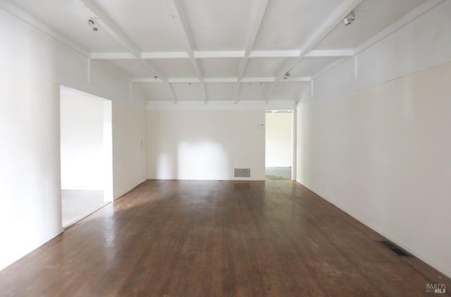 unfurnished room with beamed ceiling and hardwood / wood-style floors