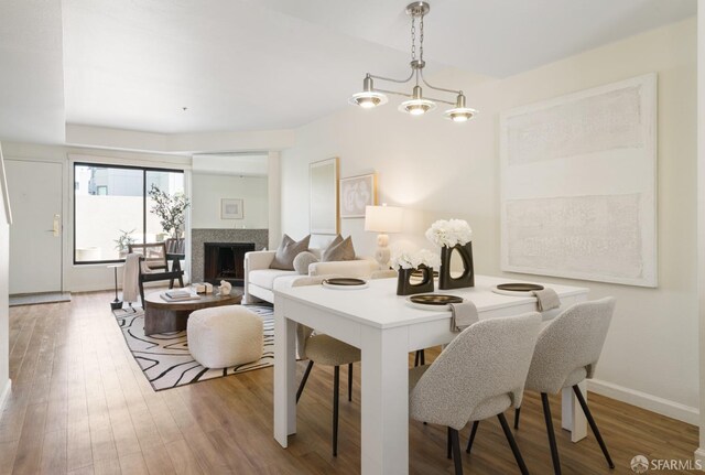 601 Van Ness Ave Unit 39, San Francisco, CA 94102 - dining room featuring an inviting chandelier, baseboards, a fireplace, and wood finished floors