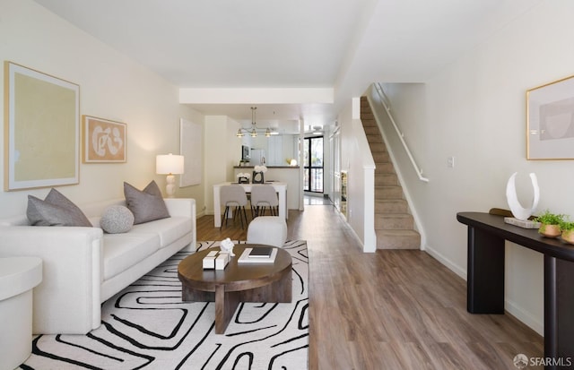 601 Van Ness Ave Unit 39, San Francisco, CA 94102 - living area featuring baseboards, wood finished floors, a notable chandelier, and stairway