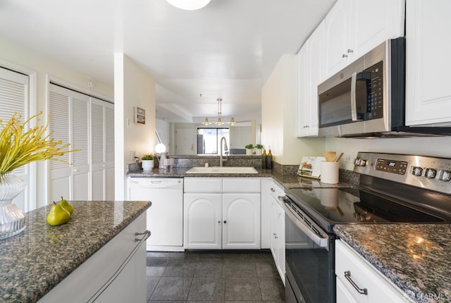 601 Van Ness Ave Unit 39, San Francisco, CA 94102 - kitchen featuring appliances with stainless steel finishes, granite finish floor, a sink, white cabinets, and dark stone counters