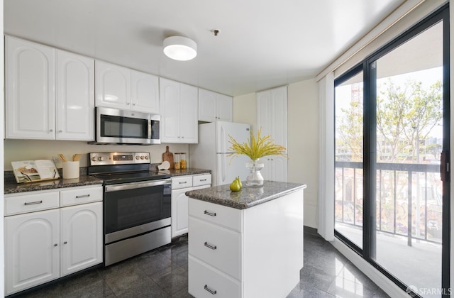 601 Van Ness Ave Unit 39, San Francisco, CA 94102 - kitchen featuring white cabinets, appliances with stainless steel finishes, granite finish floor, and dark stone counters