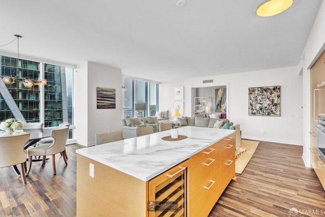 301 Mission St Unit 40D, San Francisco, CA 94105 - kitchen featuring beverage cooler, wood finished floors, healthy amount of natural light, and a center island