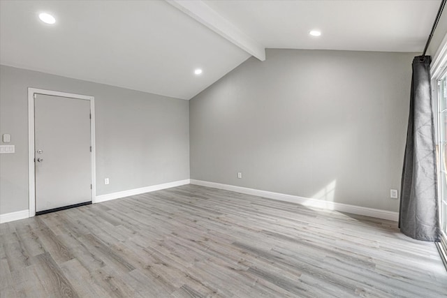 spare room with lofted ceiling with beams, light wood-style flooring, and baseboards