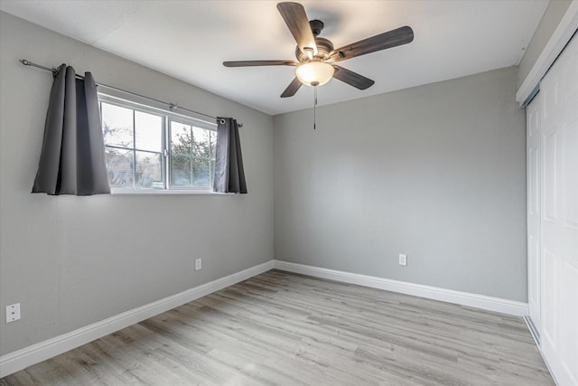 unfurnished bedroom featuring light wood finished floors, a ceiling fan, baseboards, and a closet