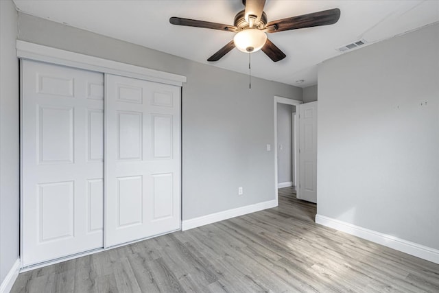 unfurnished bedroom featuring a closet, visible vents, light wood-style floors, a ceiling fan, and baseboards