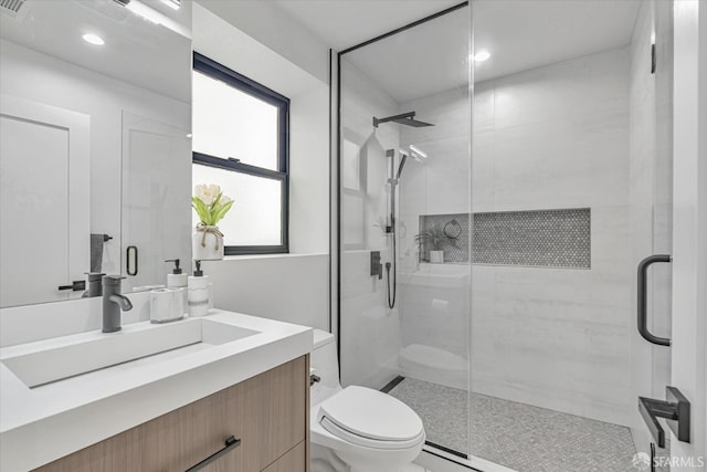 bathroom with vanity, an enclosed shower, and toilet